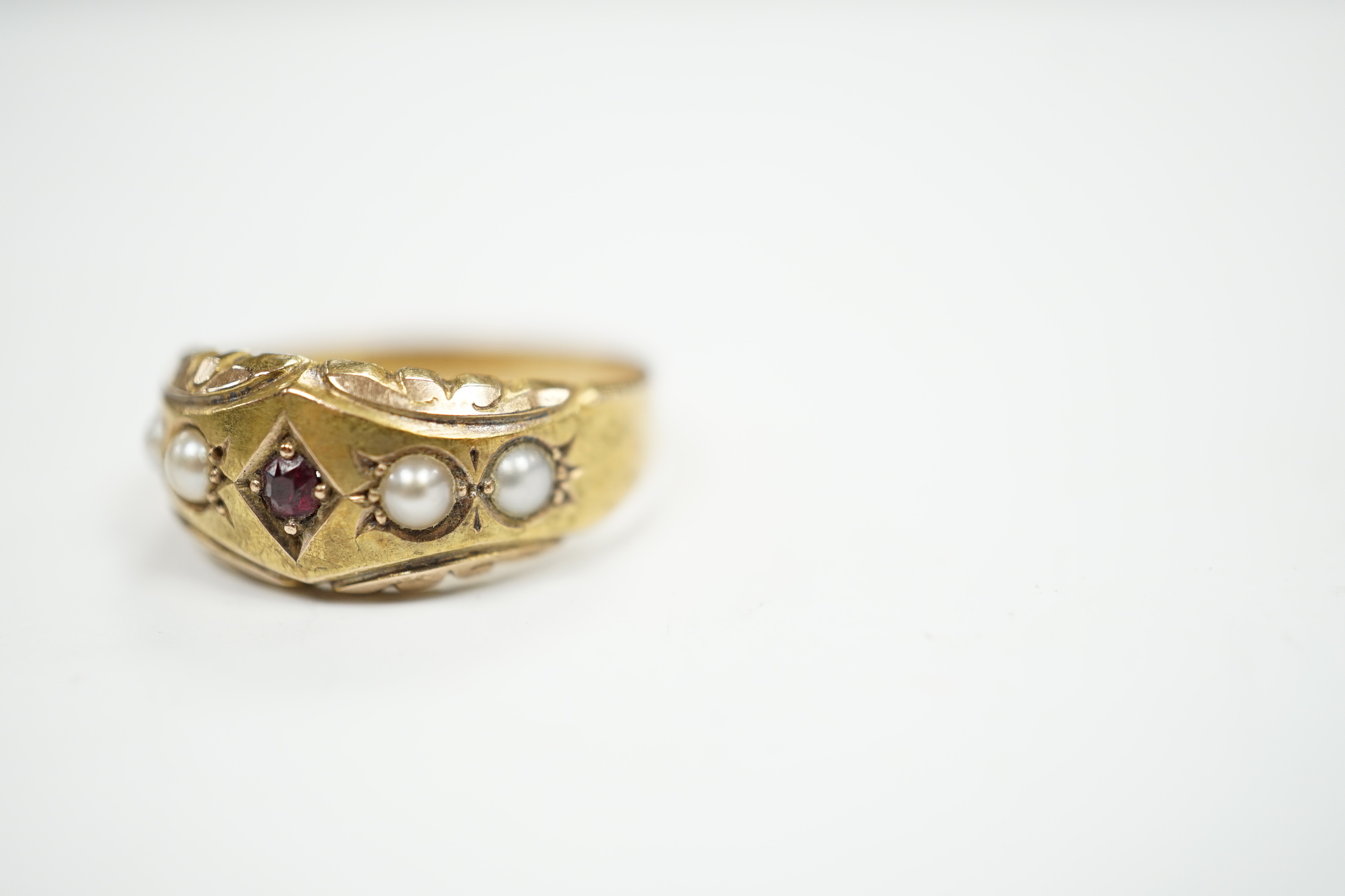 A late Victorian 15ct gold, ruby and split pearl set half hoop ring, size M, gross weight 2.7 grams.